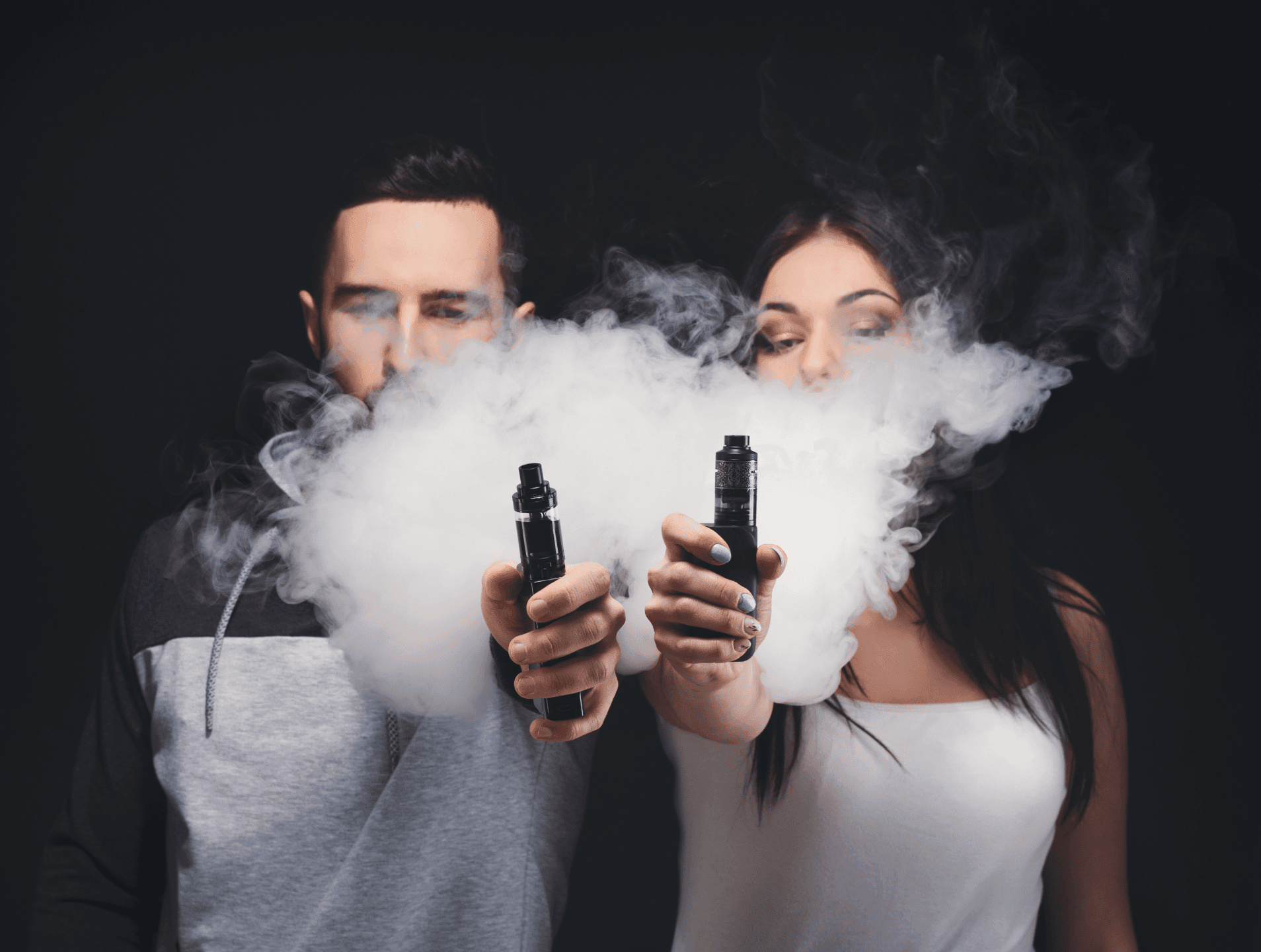 Vape clouds with young adults vaping e-cigarettes against black background.
