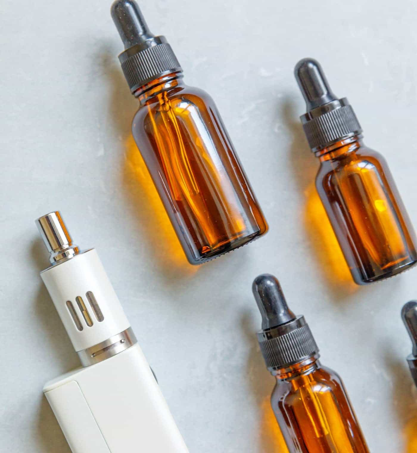 Amber glass dropper bottles with e-liquid for vaping and electronic cigarette flavors.